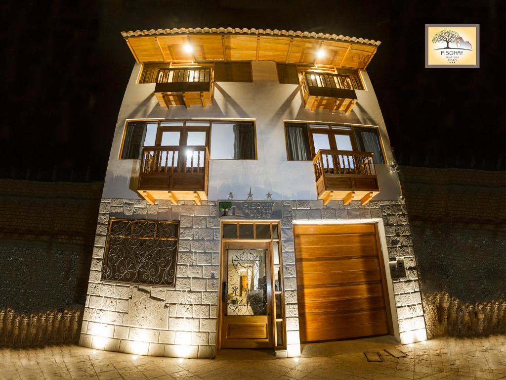 a building with lights on the front of it at Pisonay Hotel in Pisac