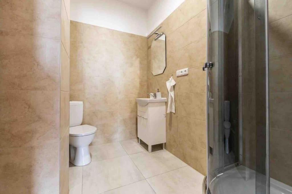 y baño con aseo, lavabo y ducha. en Modern & cozy flat near football & hockey arena en Trnávka