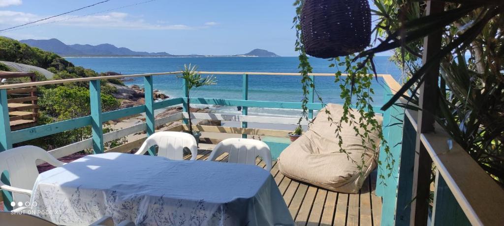 uma mesa e cadeiras numa varanda com vista para o oceano em Mona lisa em Florianópolis