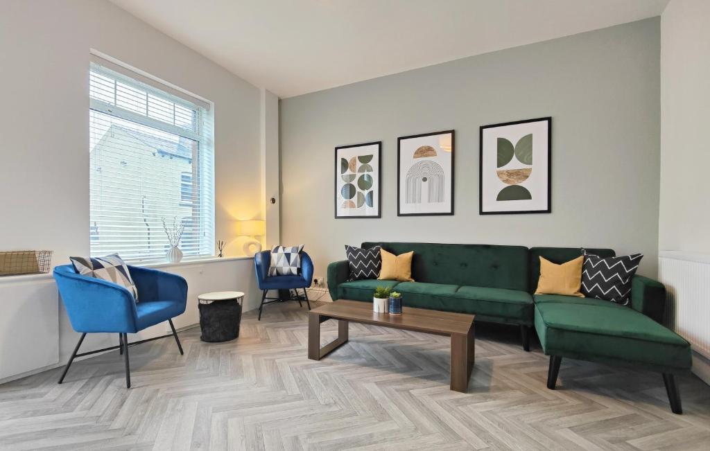 a living room with a green couch and blue chairs at Stott House - Bright Spacious Townhouse 15 Minutes to Central Manchester With Free Parking in Manchester