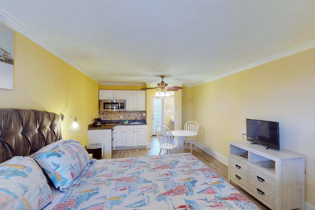 ein Wohnzimmer mit einem Sofa und einem TV sowie eine Küche in der Unterkunft Sunset Bliss in Surf City