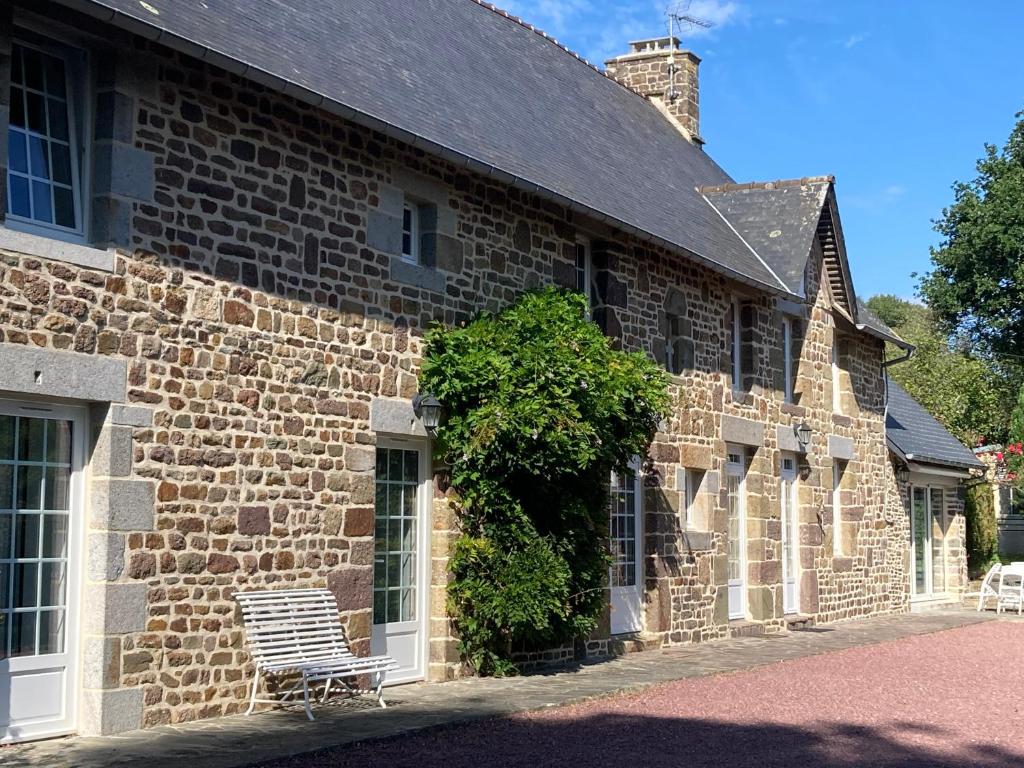 a brick building with two chairs sitting outside of it at « Le petit verger » in Hambye