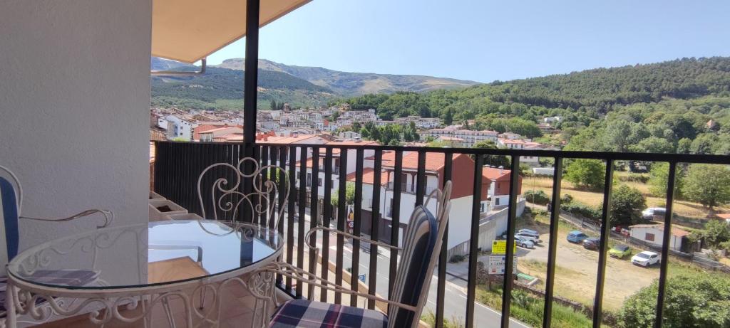 d'un balcon avec une table et une vue sur la ville. dans l'établissement Triplex Vistas Candelario, à Candelario