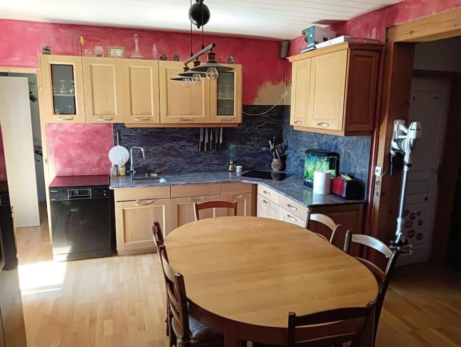 une cuisine avec une table en bois et une salle à manger dans l'établissement Le nid près du lac, à Clairvaux-les-Lacs