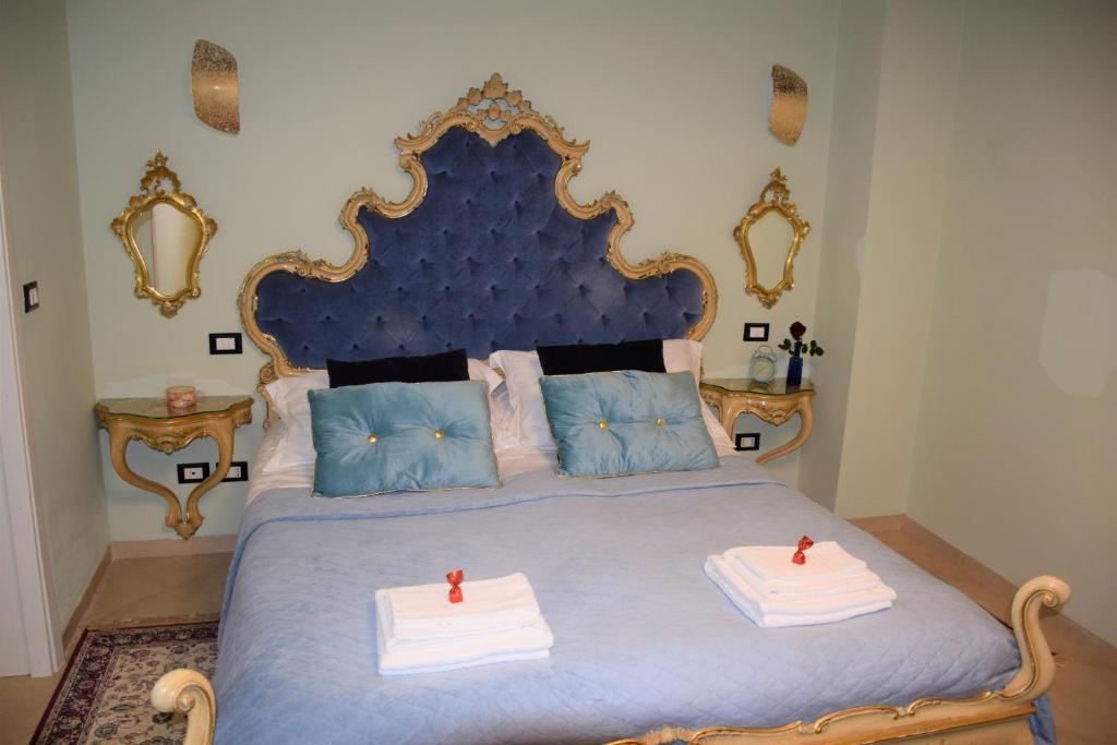 a bedroom with a blue bed with two red candles on it at Le Pizzocchere in Venice