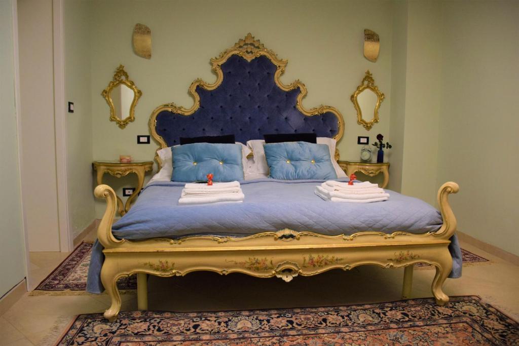ヴェネツィアにあるLe Pizzocchereのベッドルーム1室(ブルー&ゴールドベッド、タオル付)
