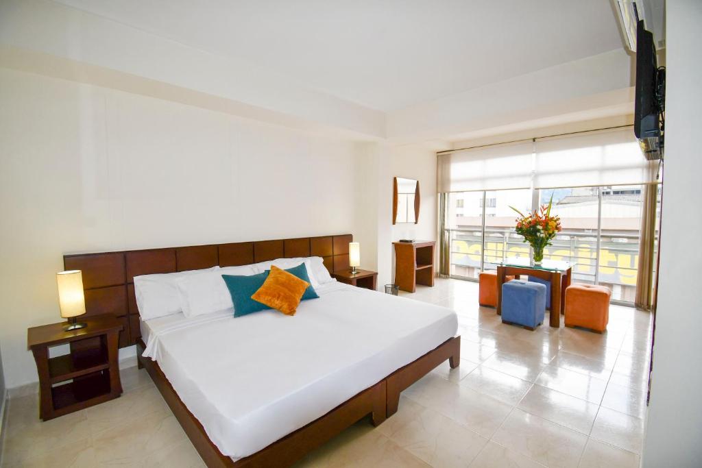 1 dormitorio con cama grande y ventana grande en Hotel Monarca Armenia, en Armenia