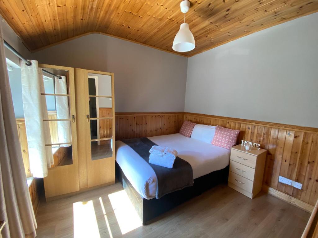 a bedroom with a bed and a wooden ceiling at Cosy City Centre Guest Room Shared Home in Galway