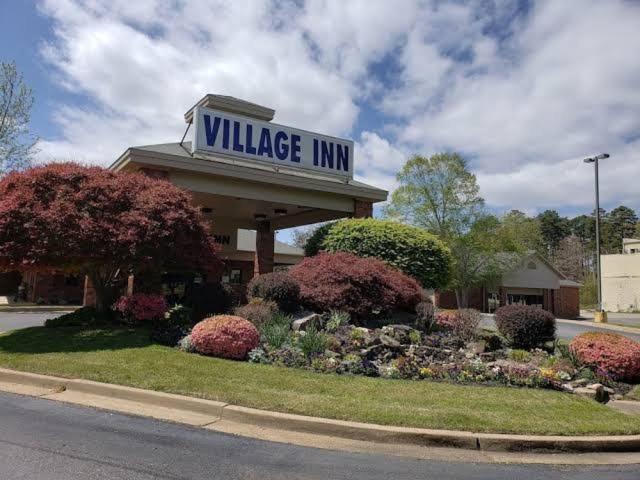 Hot Springs Village Inn في Hot Springs Village: علامة نزل القرية فوق المبنى