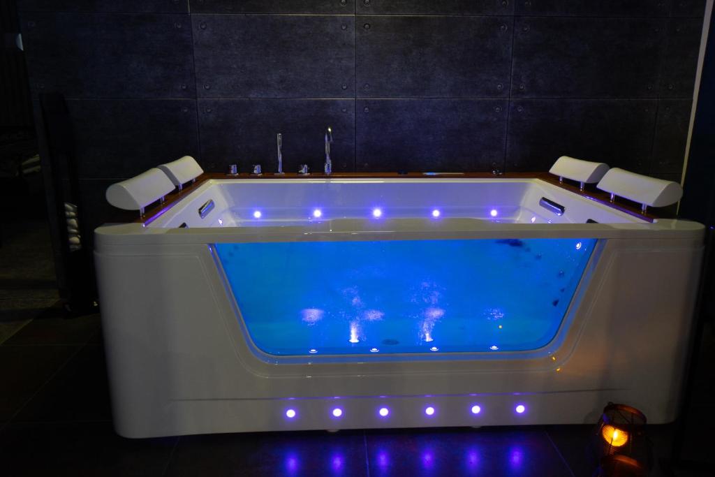 Cette chambre dispose d'une baignoire avec une piscine bleue. dans l'établissement Szampan i Truskawka, à Toruń
