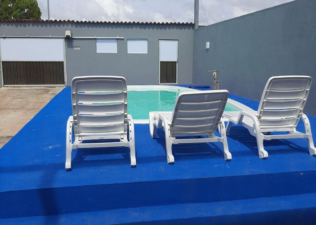 duas cadeiras e uma mesa em frente a uma piscina em L & C - Casa por Temporada em Macapá