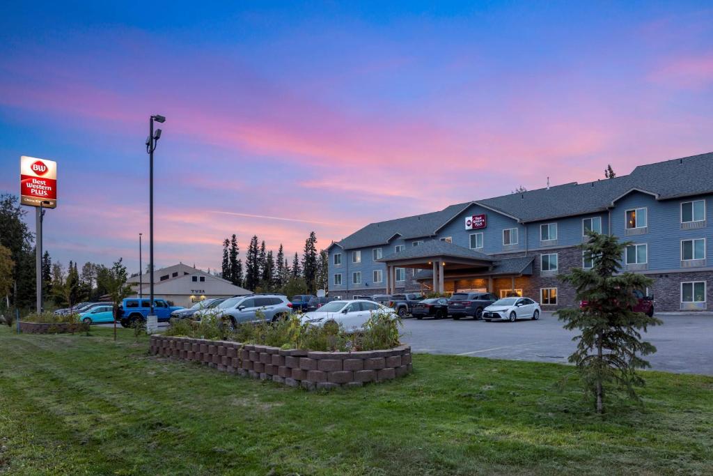 een hotel met auto's geparkeerd op een parkeerplaats bij Best Western Plus Chena River Lodge in Fairbanks
