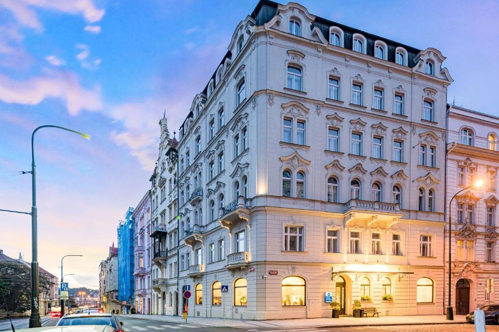 - un grand bâtiment blanc dans une rue de la ville dans l'établissement Best Western Hotel Moran, à Prague