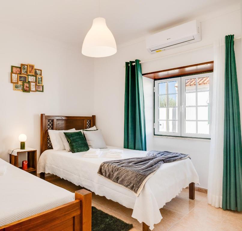 a bedroom with two beds and a window at Lugar do Regato - Alojamento Local in Portel