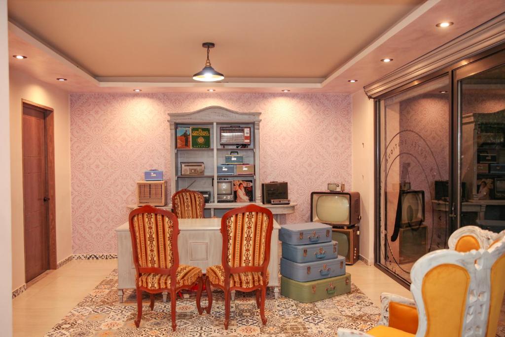 Zimmer mit einem Schreibtisch mit Stühlen und einem TV in der Unterkunft Añoranza Hotel Boutique in Ciudad Hidalgo