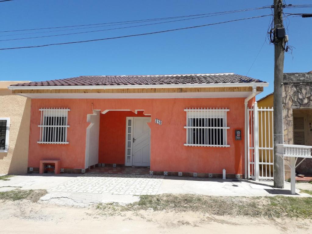 una casa roja con una puerta blanca en Madreselva en Chuí