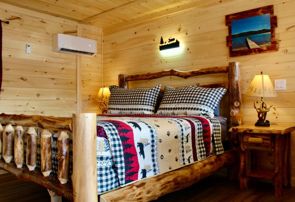 um quarto com uma cama num chalé de madeira em The Sundowner on Lake George em Lake George