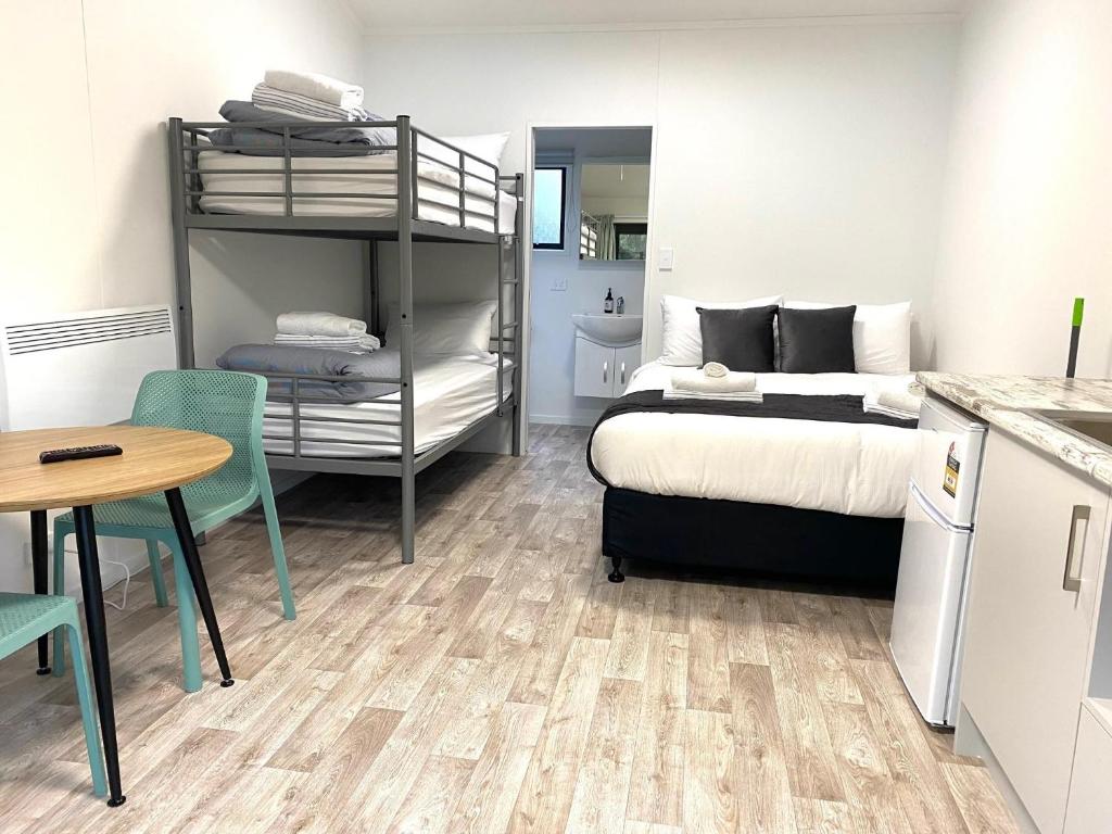 - une chambre avec des lits superposés et une table dans l'établissement Tasman Holiday Parks - Waihi Beach, à Waihi Beach