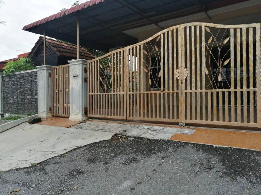 a wooden gate in front of a house at SRI WANG HOMESTAY @ ARAU in Arau