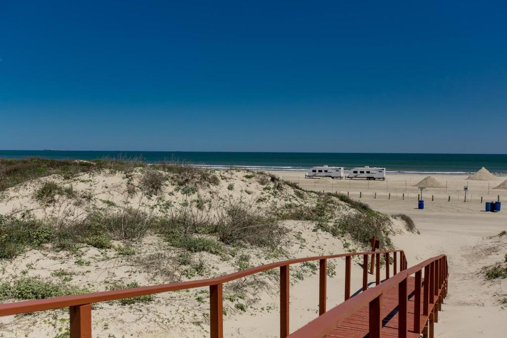a sandy beach with a wooden path to the beach at On the Half Shell - Condo in Port Aransas