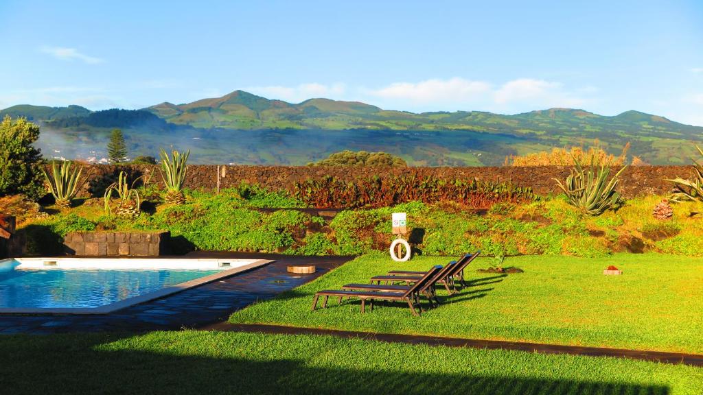 聖文森費黑拉的住宿－Sao Vicente Lodge - Atlantic Retreat，后院设有游泳池、2把椅子和1张桌子