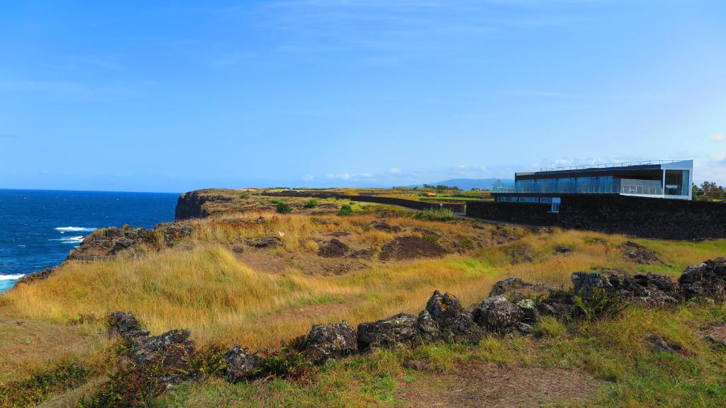 a building on a hill next to the ocean at Sao Vicente Lodge - Atlantic Retreat in São Vicente Ferreira