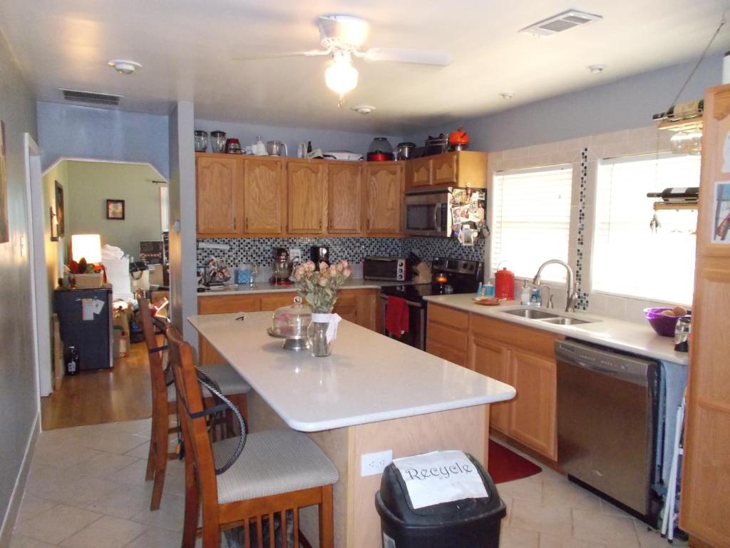 cocina con armarios de madera y encimera blanca en Yorkshire Estates, en Manassas