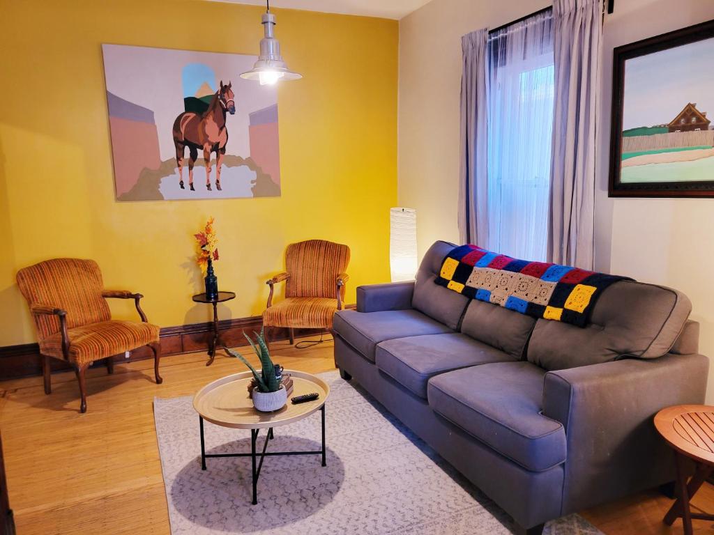 a living room with a couch and a horse on the wall at Dundurn Dwelling-Charming Century Home in Hamilton