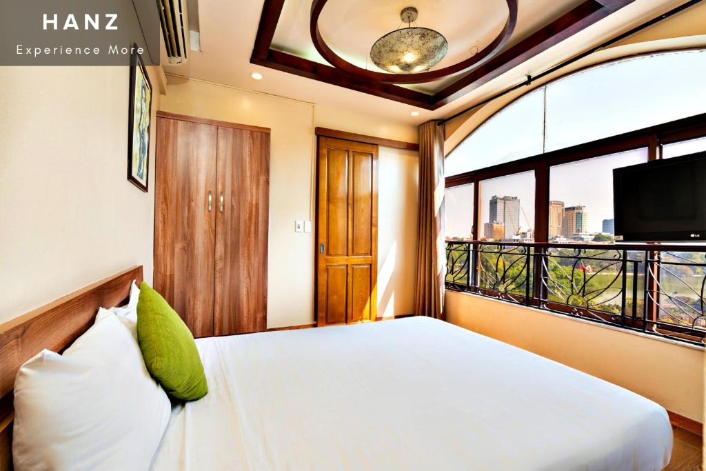 a bedroom with a bed and a large window at HANZ LakeView Hotel Hanoi in Hanoi