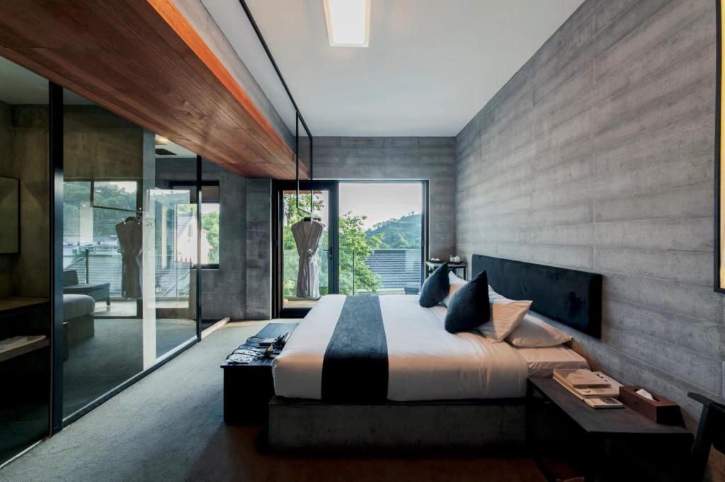 a bedroom with a large bed and a large window at Hangzhou Spring B&B in Hangzhou