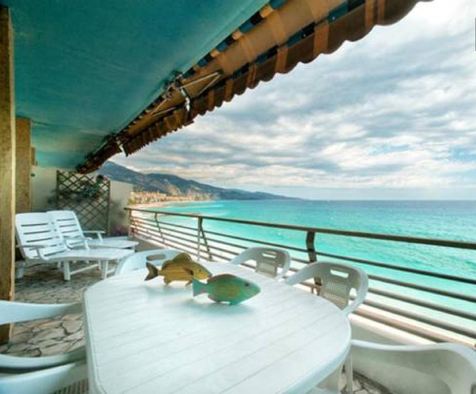 a white table and chairs with a view of the ocean at Flat Rossi in Menton