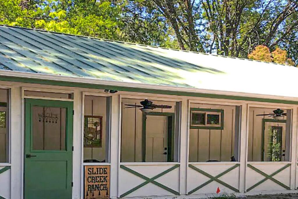 een koetshuis met een groene deur en ramen bij Slide Creek Ranch 1 mile to Bass Lake on 25 acres in Bass Lake