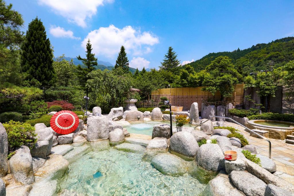 a swimming pool in a garden with rocks and trees at TAOYA Kisoji in Nagiso