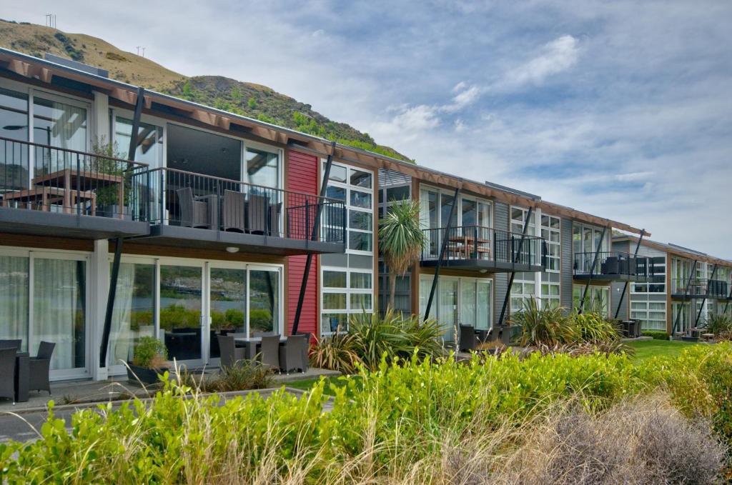 an apartment building with balconies and a mountain in the background at Absolute Lake Front Luxury- 2 bedroom apartment in Queenstown