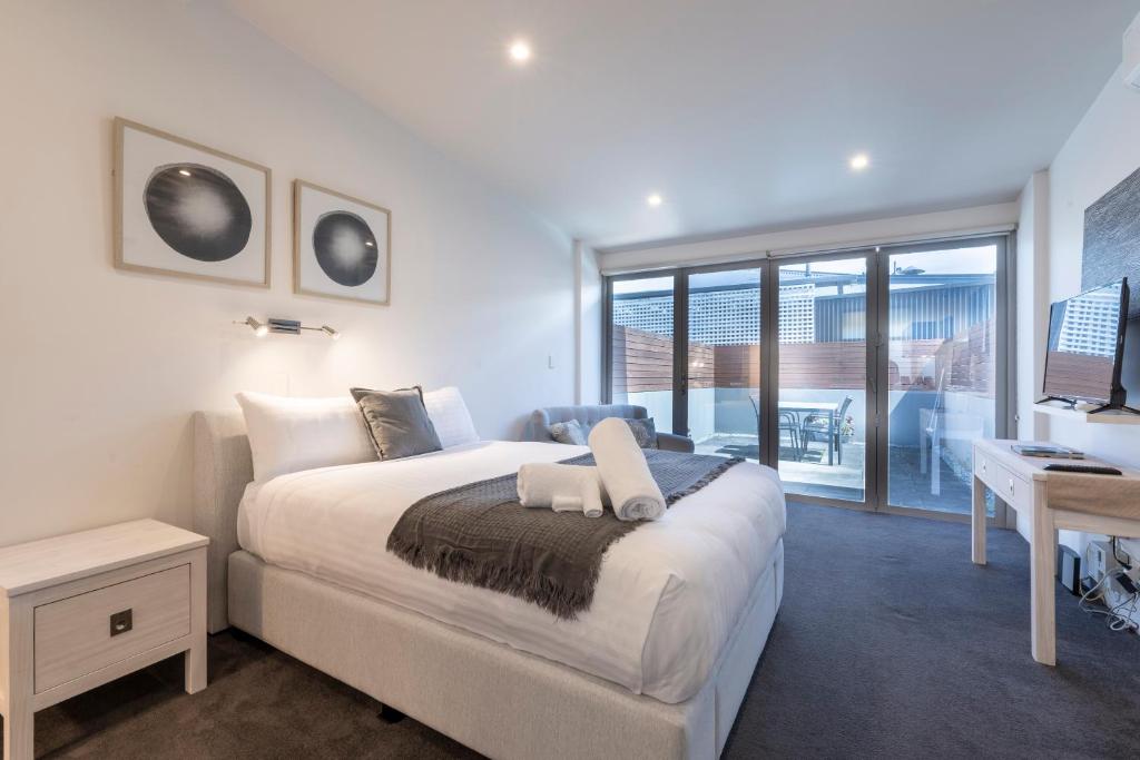 a bedroom with a bed and a desk and a window at Studio Apartment - 5 Minutes to Hobart CBD - Free Parking - Free WIFI in Sandy Bay