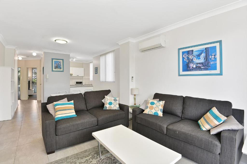 a living room with two couches and a table at Ocean Palms Unit 1 in The Entrance