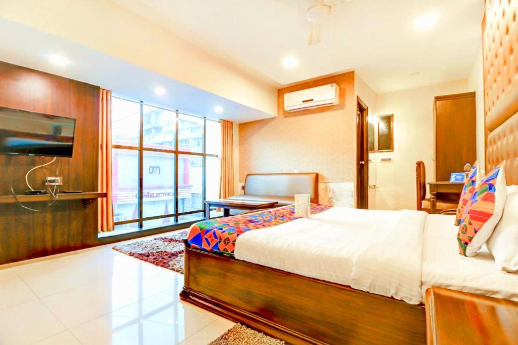 a bedroom with a bed and a desk and a television at Hotel R DELUXE "Couple Friendly Vaccinated Staff" in New Delhi