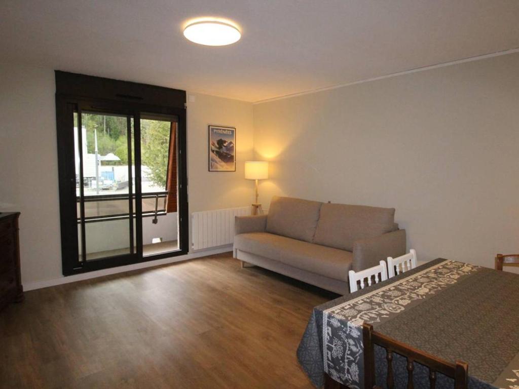 un salon avec un canapé et une fenêtre dans l'établissement LUCHON T2 RENOVÉ AVEC BALCON ET PARKING - FR-1-313-211, à Luchon