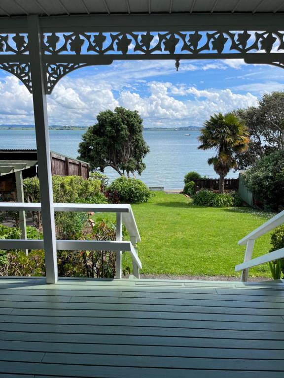 uma vista para o oceano a partir do alpendre de uma casa em Tamaterau Seaview House in Whangarei em Whangarei