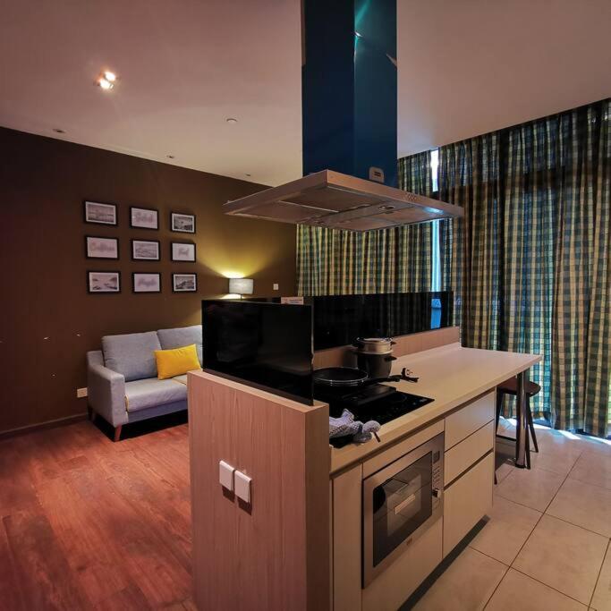 uma cozinha com um fogão e uma sala de estar em Walker's Suite@Riverson Soho superior one Bedroom em Kota Kinabalu
