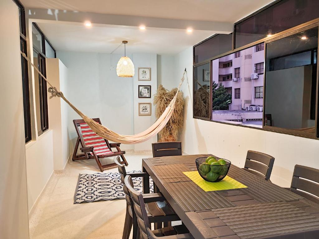 ein Esszimmer mit einer Hängematte sowie einem Tisch und Stühlen in der Unterkunft Apartamento Rodadero Santa Marta Edificio Santorini in Rodadero