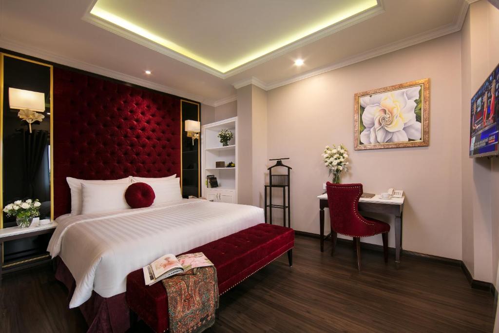 a bedroom with a large bed and a red headboard at Flora Centre Hotel & Spa in Hanoi