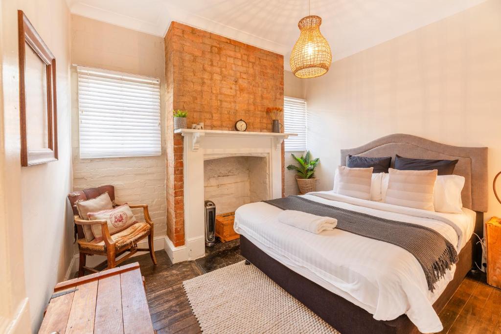 a bedroom with a large bed and a fireplace at The Edward Townhouse 155 - Steps to Town in Orange
