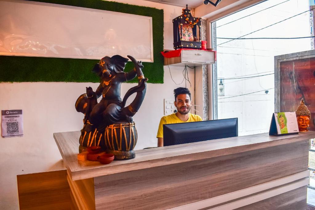 a man sitting at a counter with a statue at Skyard Premium, Tapovan in Rishīkesh