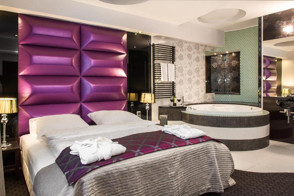 sypialnia z dużym łóżkiem i wanną w obiekcie Hotel Zimowit w mieście Rzeszów