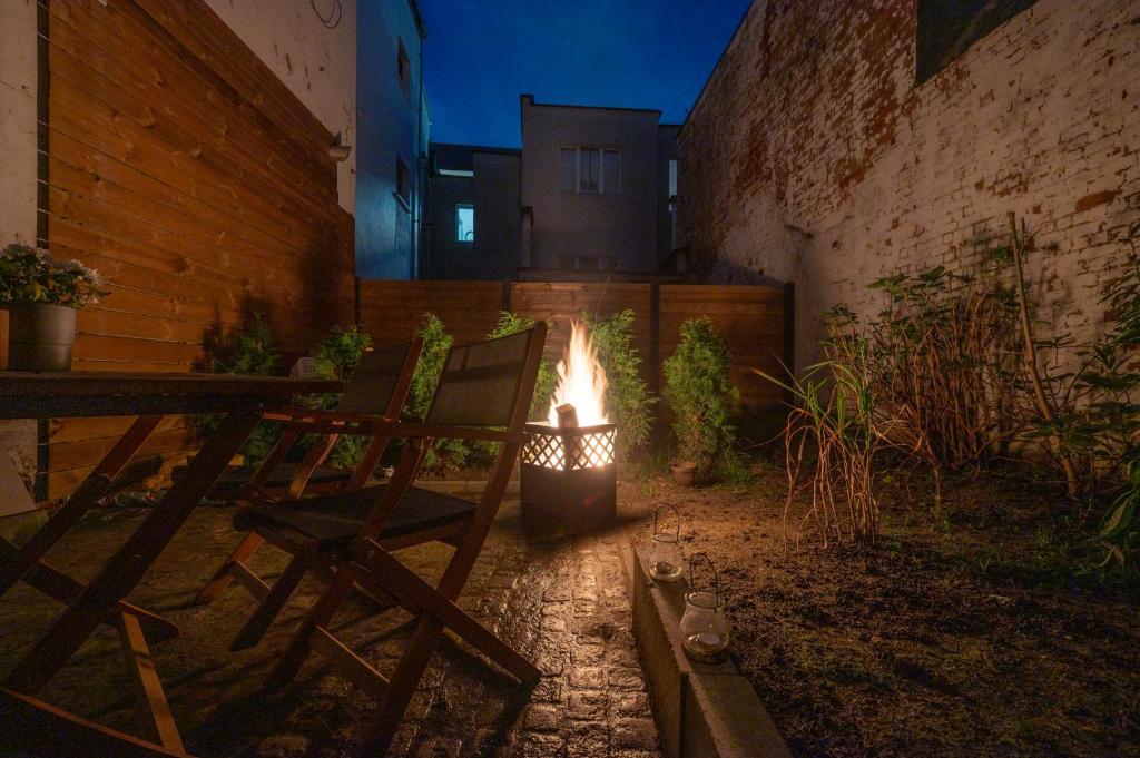 安特衛普的住宿－Garden Suite in city center，庭院内的火坑,配有两把椅子和一个壁炉
