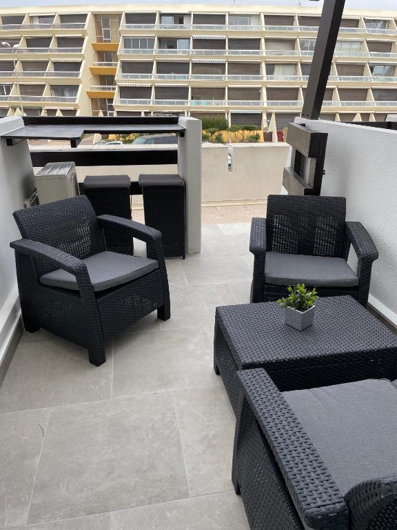 patio z krzesłami i stołami w budynku w obiekcie Golden Paradise 007 Port Nat w Cap d'Agde
