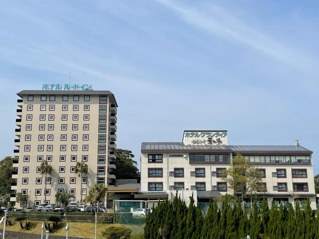 two tall buildings with a sign on top of them at Route Inn Grantia Aoshima Taiyokaku in Miyazaki