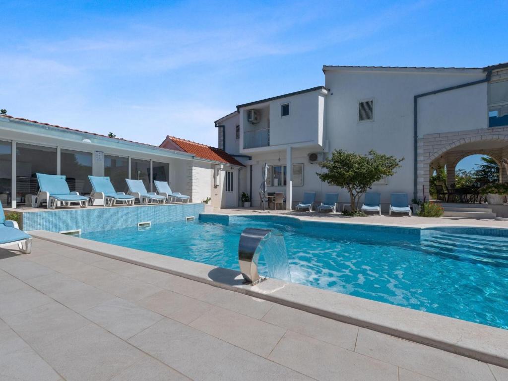 a swimming pool with chairs and a building at Beautiful Holiday Home in Neoric in Neorić