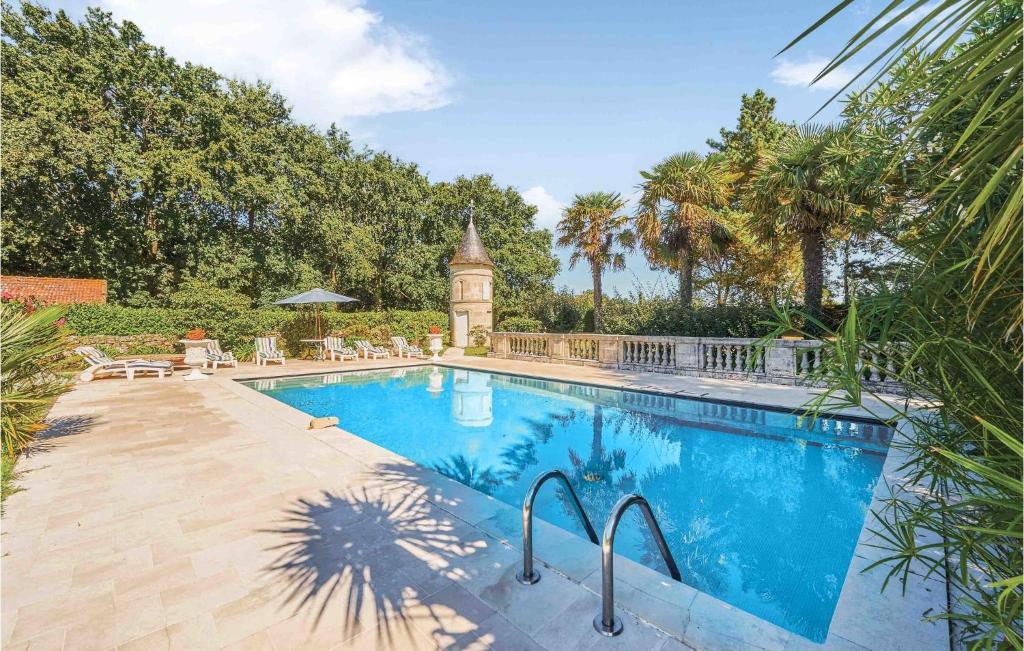 una piscina con una torre de reloj en el fondo en Cozy Home In Saint-vivien-de-medoc With Wifi, en Saint-Vivien-de-Médoc